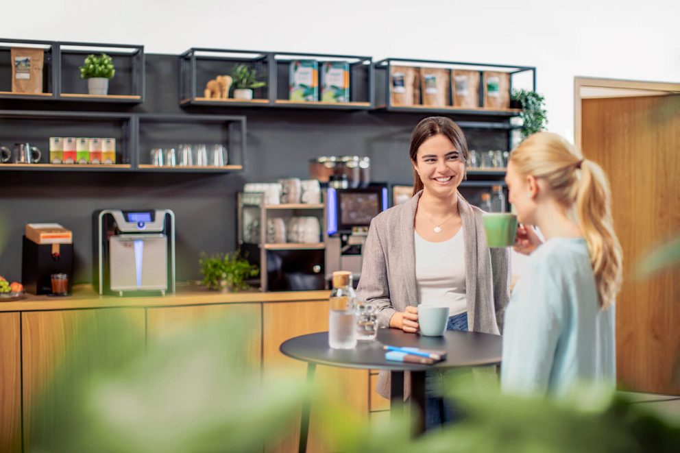 Kolleginnen unterhalten sich in der Kaffeeküche