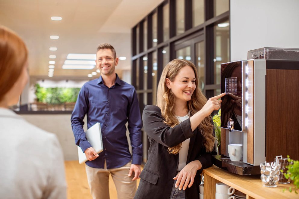 Kollegen in der Kaffeeküche holen sich einen Kaffee