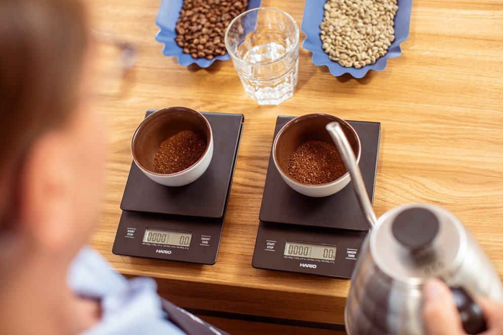 Vorbereiten von Cupping: Kaffeemehl wird mit heißem Wasser übergossen