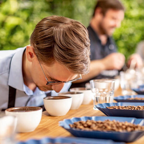 Kaffee-Einkäufer Tim Eggel riecht an einer frisch gebrühten Tasse Kaffee