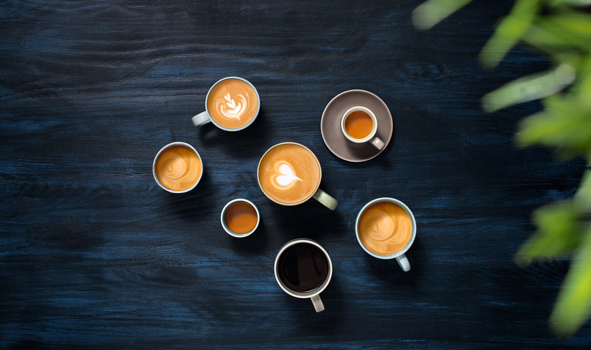 verschiedene Kaffeegetränke auf einer Holzplatte