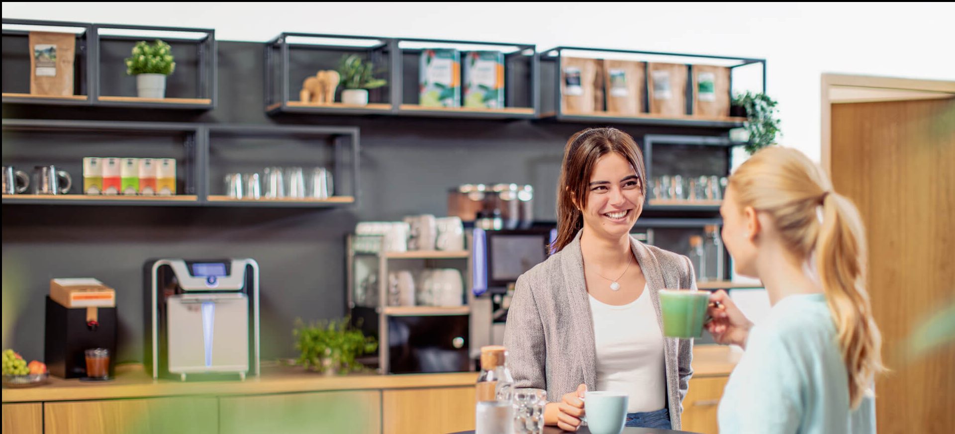 Kollegen unterhalten sich bei einem Kaffee in der Kaffeeküche