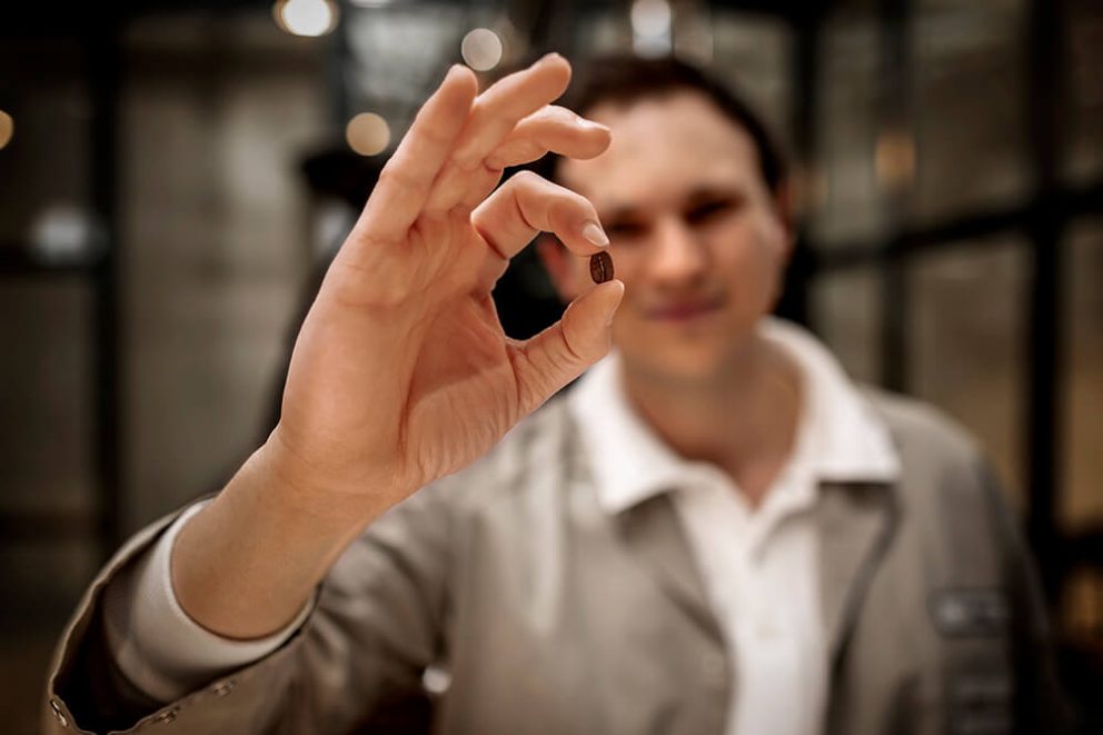 Seeberger Röstmeister hält Röstkaffeebohne in der Hand