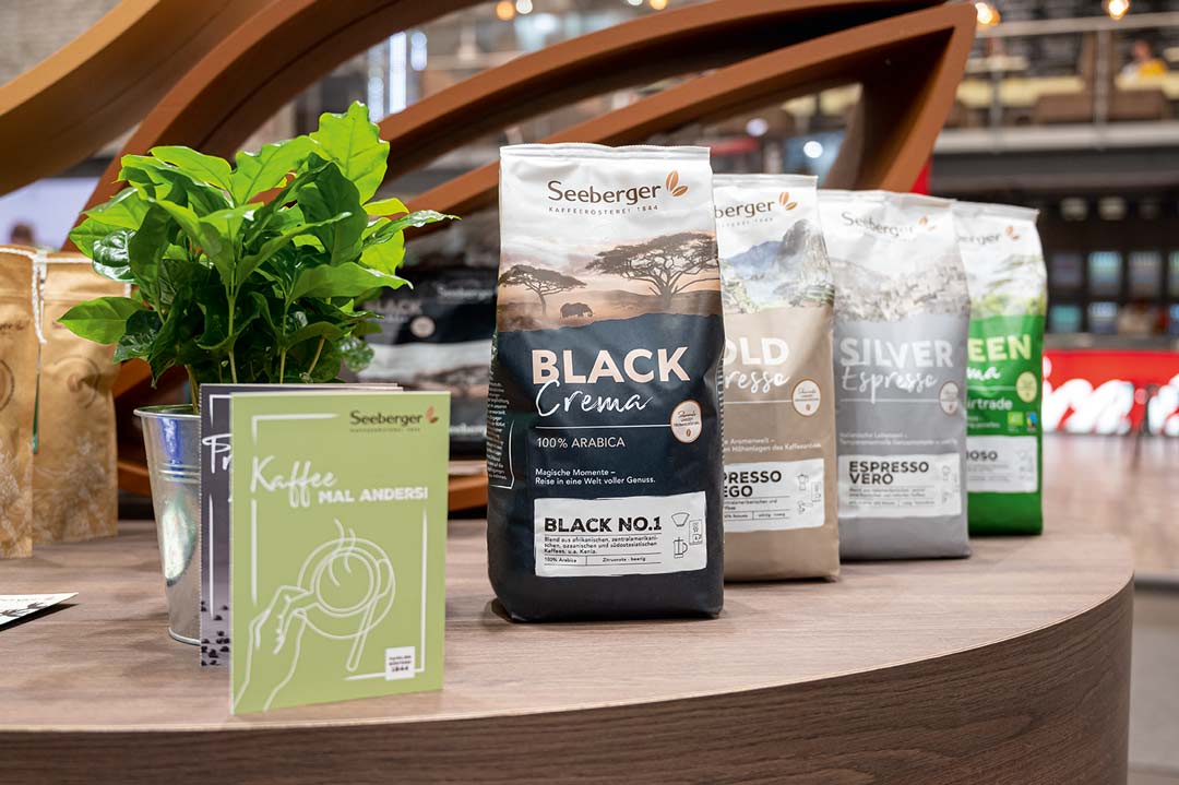 Neue Seeberger Kaffeeverpackungen in einer Reihe auf einem Holztisch