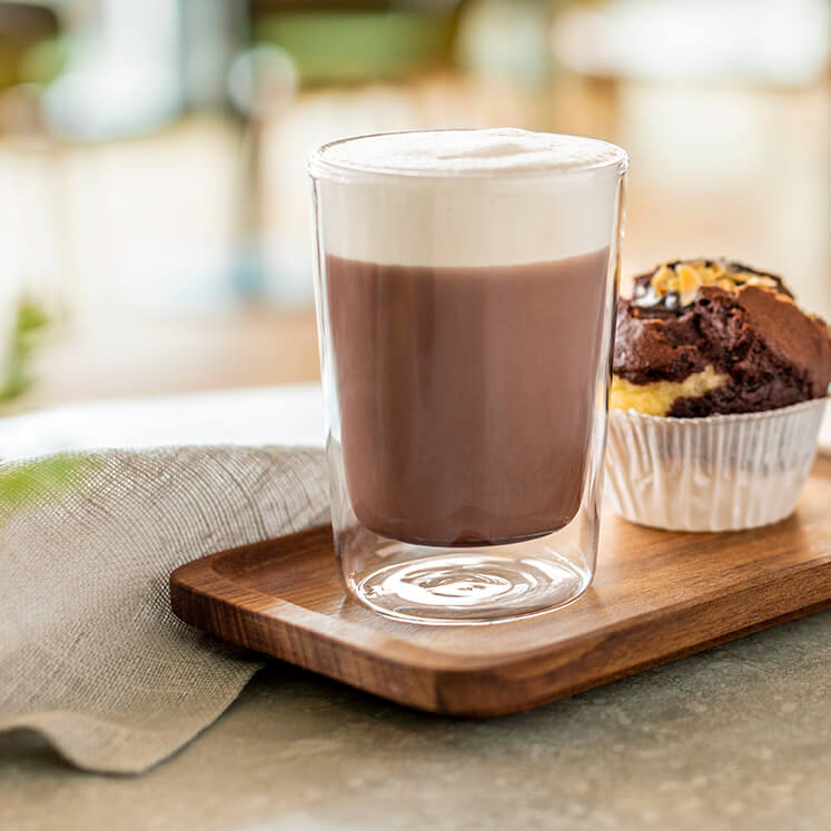 Heiße Schokolade und Muffin auf einem Holztablett