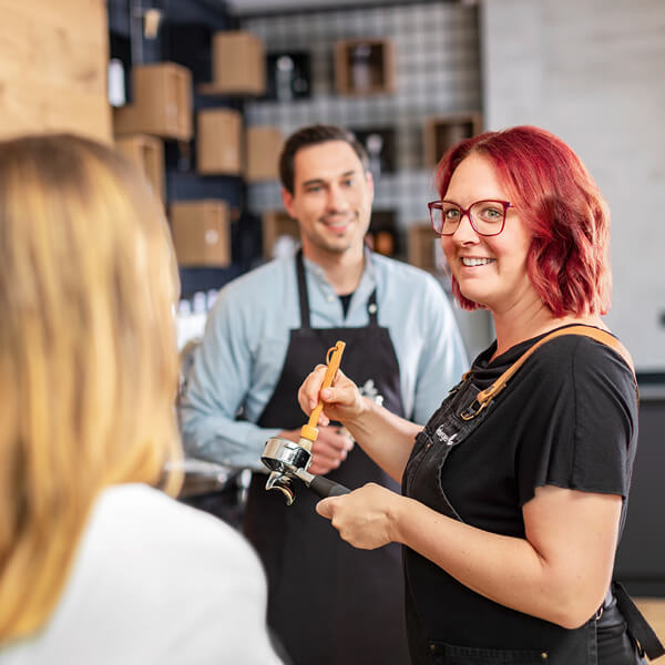 Barista erklärt den Teilnehmern die Siebträgermaschine