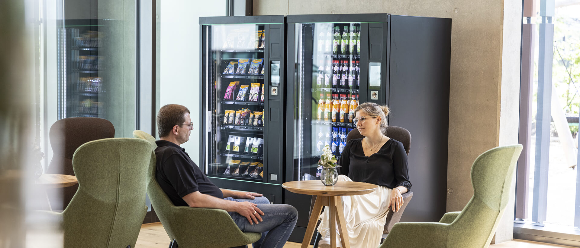 Kollegen tauschen sich aus und genießen Produkte aus dem Vendingautomat