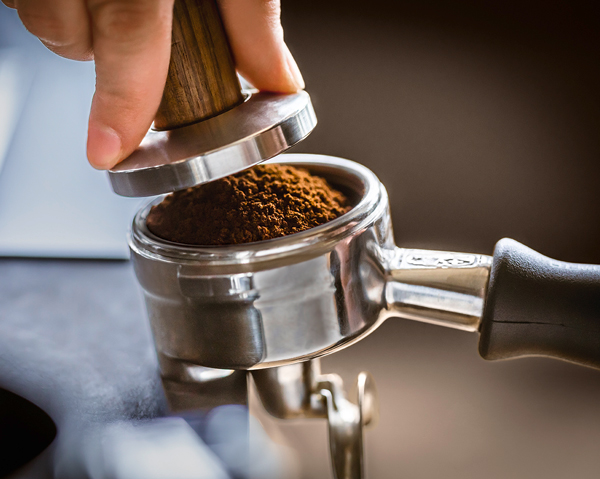 Kaffeemehl wird im Siebträger getampt