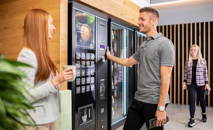 Kollegen holen sich Getränke am Vendingautomat