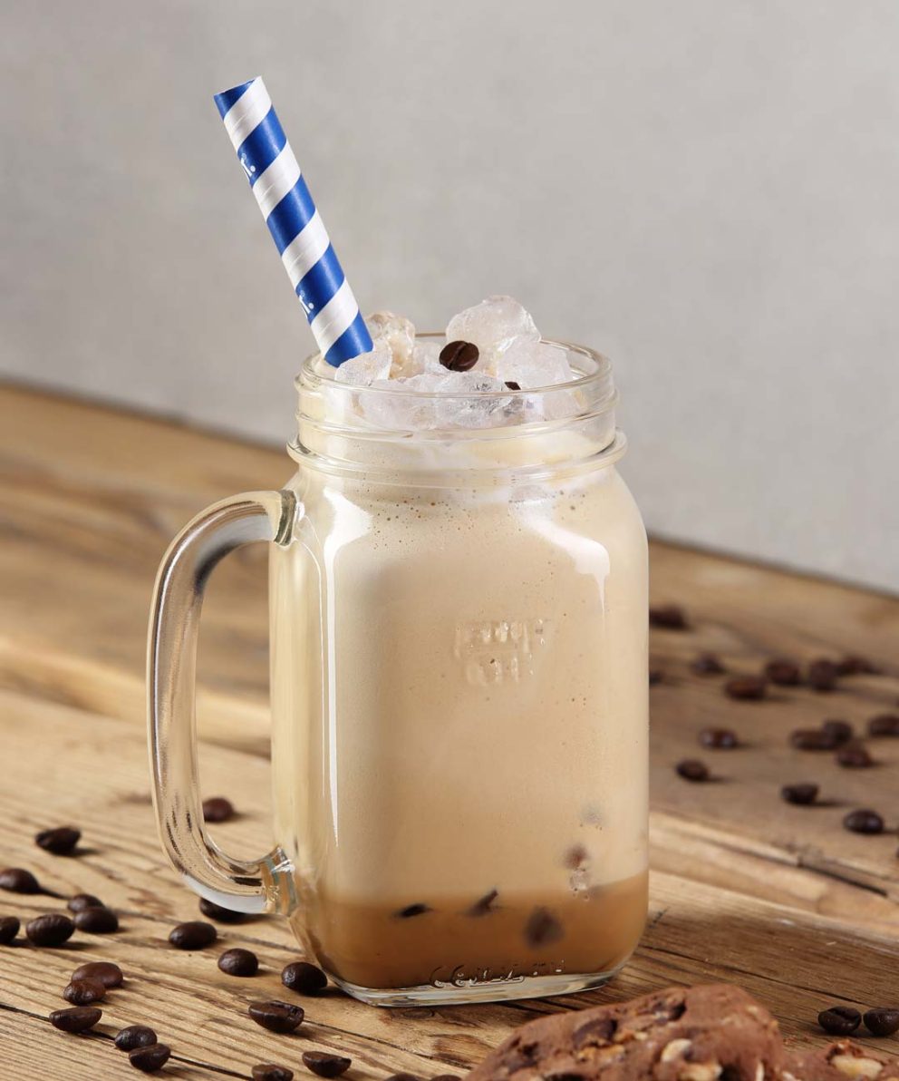 Low Fat Coffee im Henkelglas mit Strohhalm und Eiswürfel