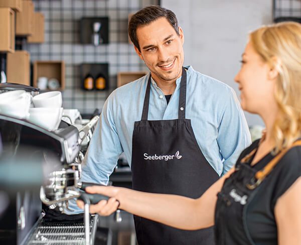 Seminarleiter erklärt Teilnehmer die Siebträgermaschine