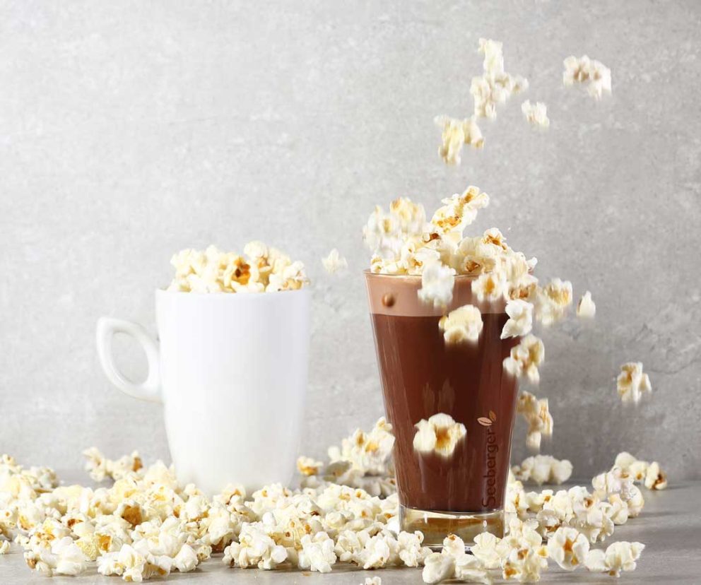 Tasse und Glas mit heißer Schokolade und Popcorn