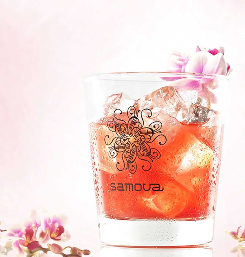 Eistee-Cocktail mit Eiswürfen und Blüten im Glas