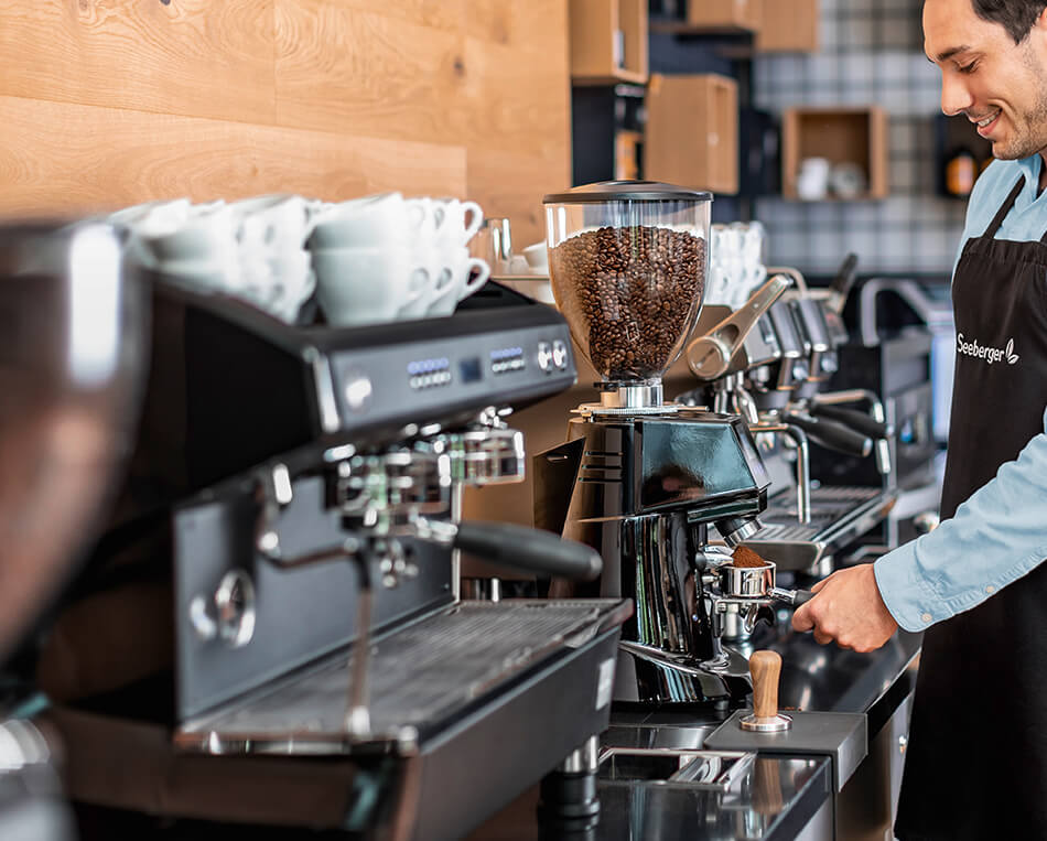 Person mahlt frischen Kaffee für die Siebträgermaschine