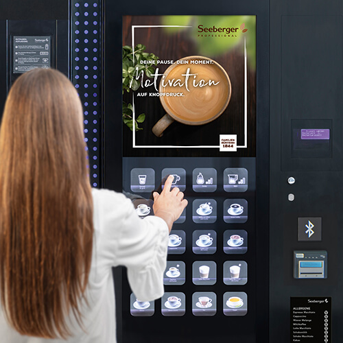 Person wählt Kaffee am Vendingautomat